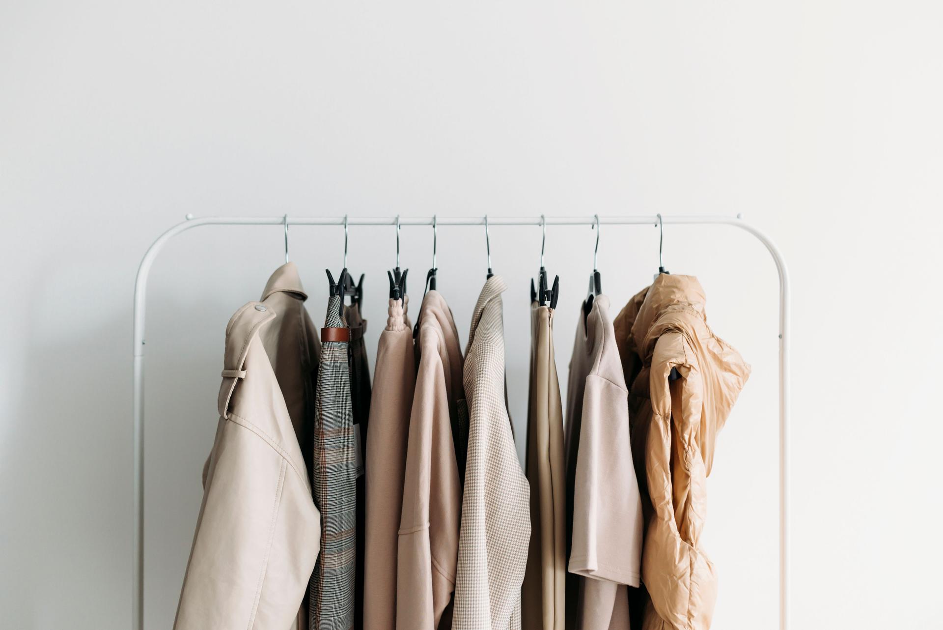 capsule clothes of beige coloron a rack. Closeup